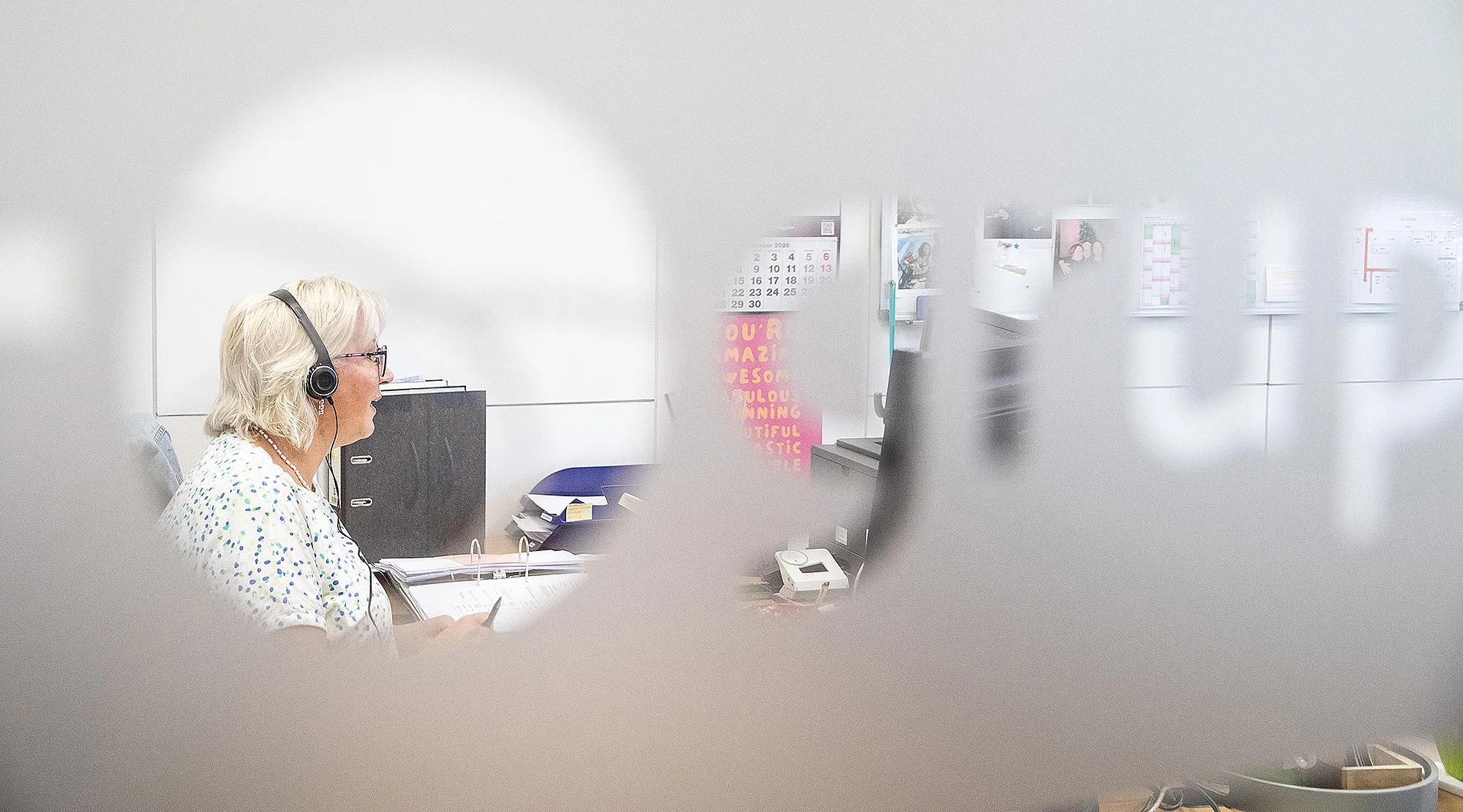Einblick durch die Glaswand in den Arbeitsalltag der Scheurer-Gruppe